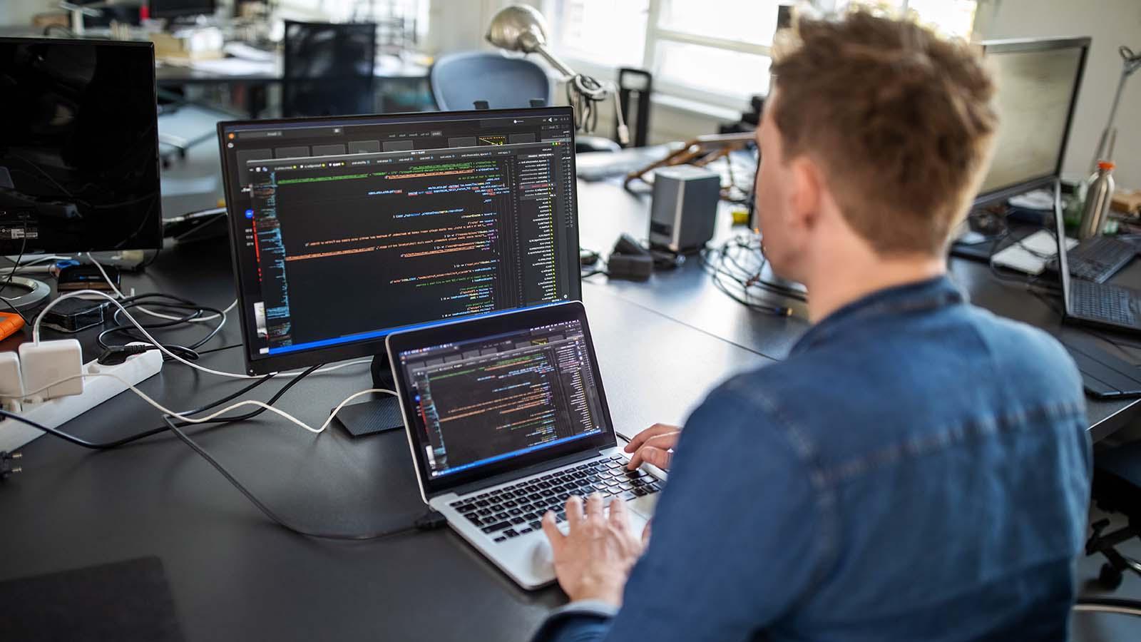 Male professional sitting at his office desk and working on a new software program.